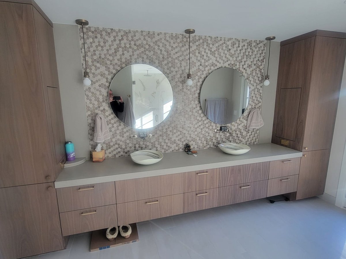 Custom bathroom design featuring dual sinks, gold pendant lighting, and a warm neutral color palette in the Frankel remodel by Thomas Buckborough & Associates