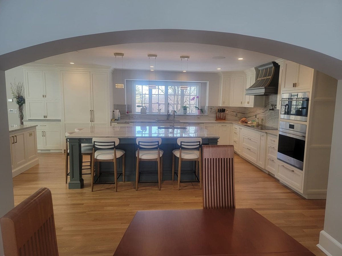 Elegant kitchen remodel in Acton, MA, by Thomas Buckborough & Associates, featuring a marble island and white cabinetry