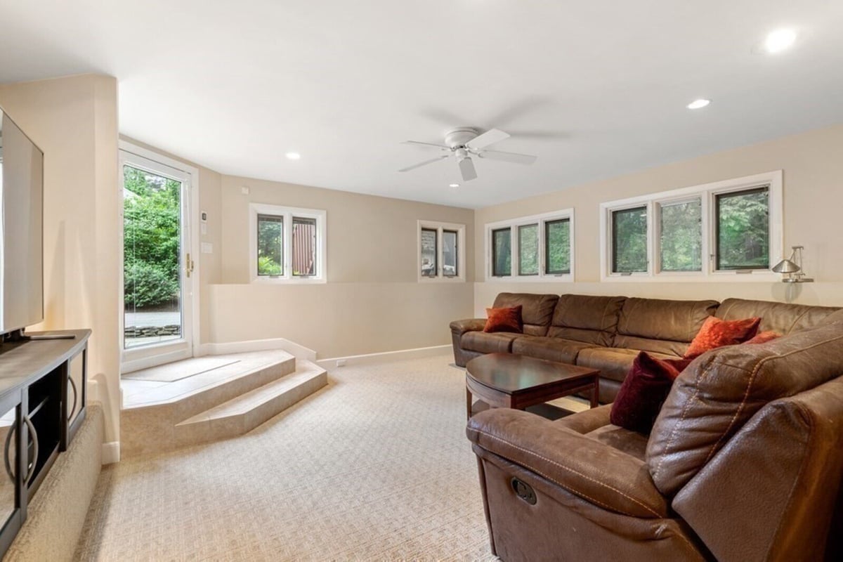 Acton MA remodeled family room with leather sectional seating and patio access by Thomas Buckborough & Associates