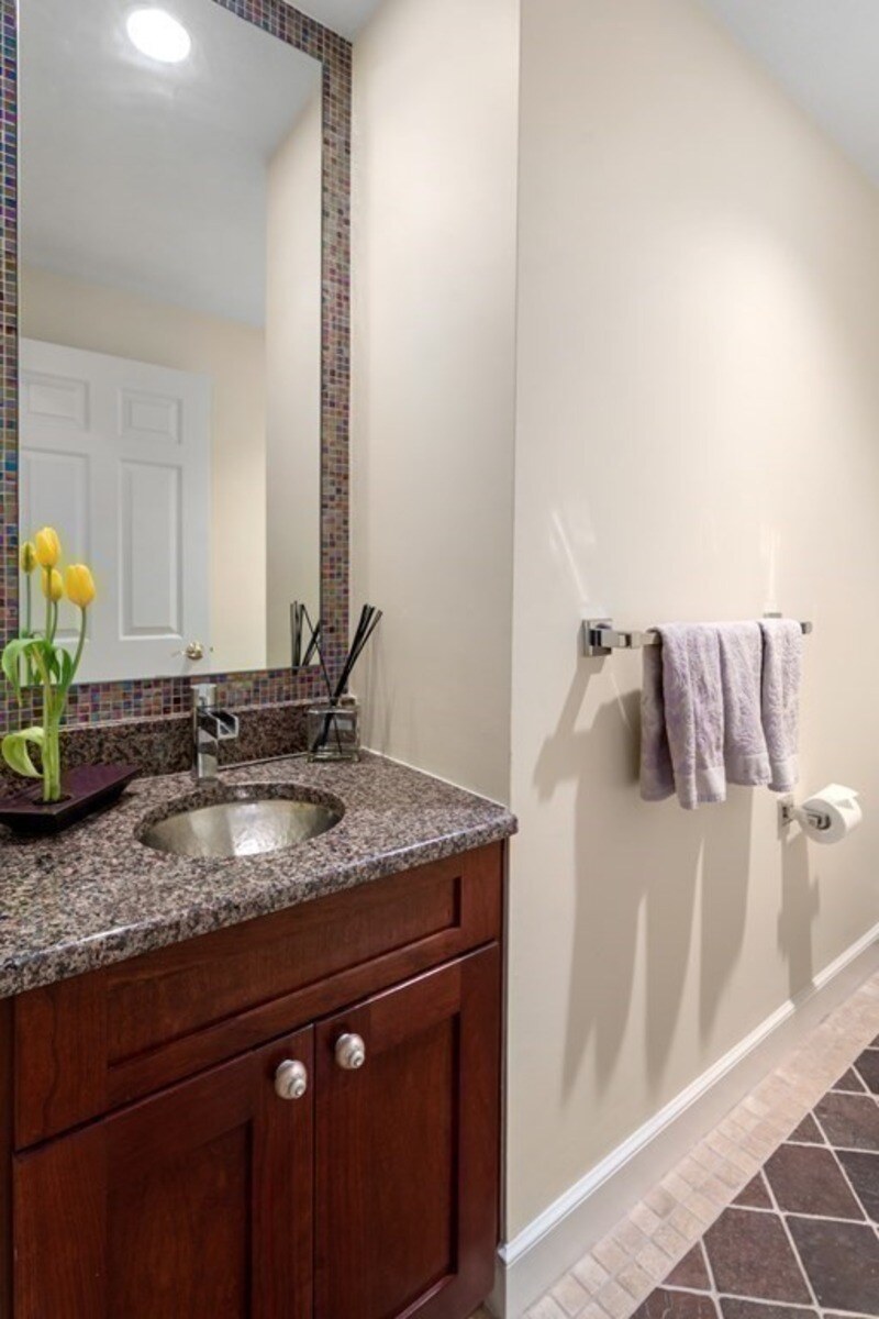 Acton homes remodeled powder room highlighting a granite vanity top and custom mosaic mirror design by Thomas Buckborough & Associates