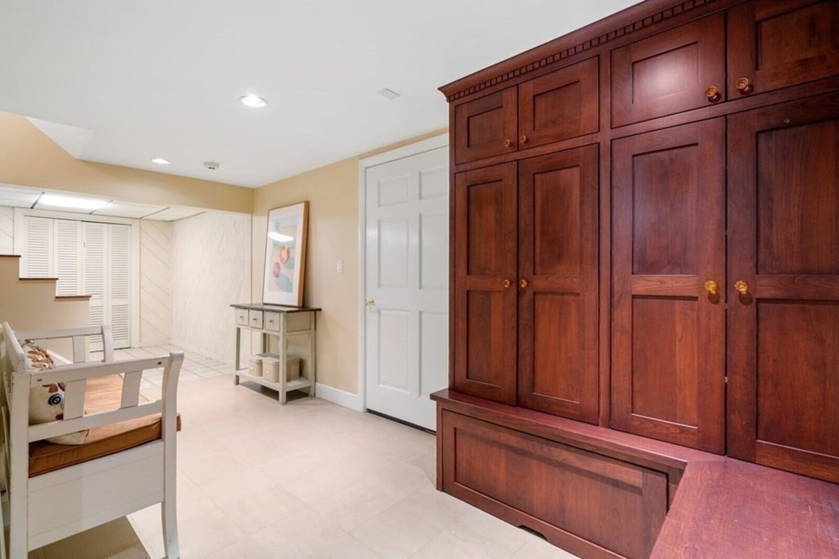 Basement entryway with built-in wooden cabinetry and storage from home remodel by Thomas Buckborough & Associates, Acton MA
