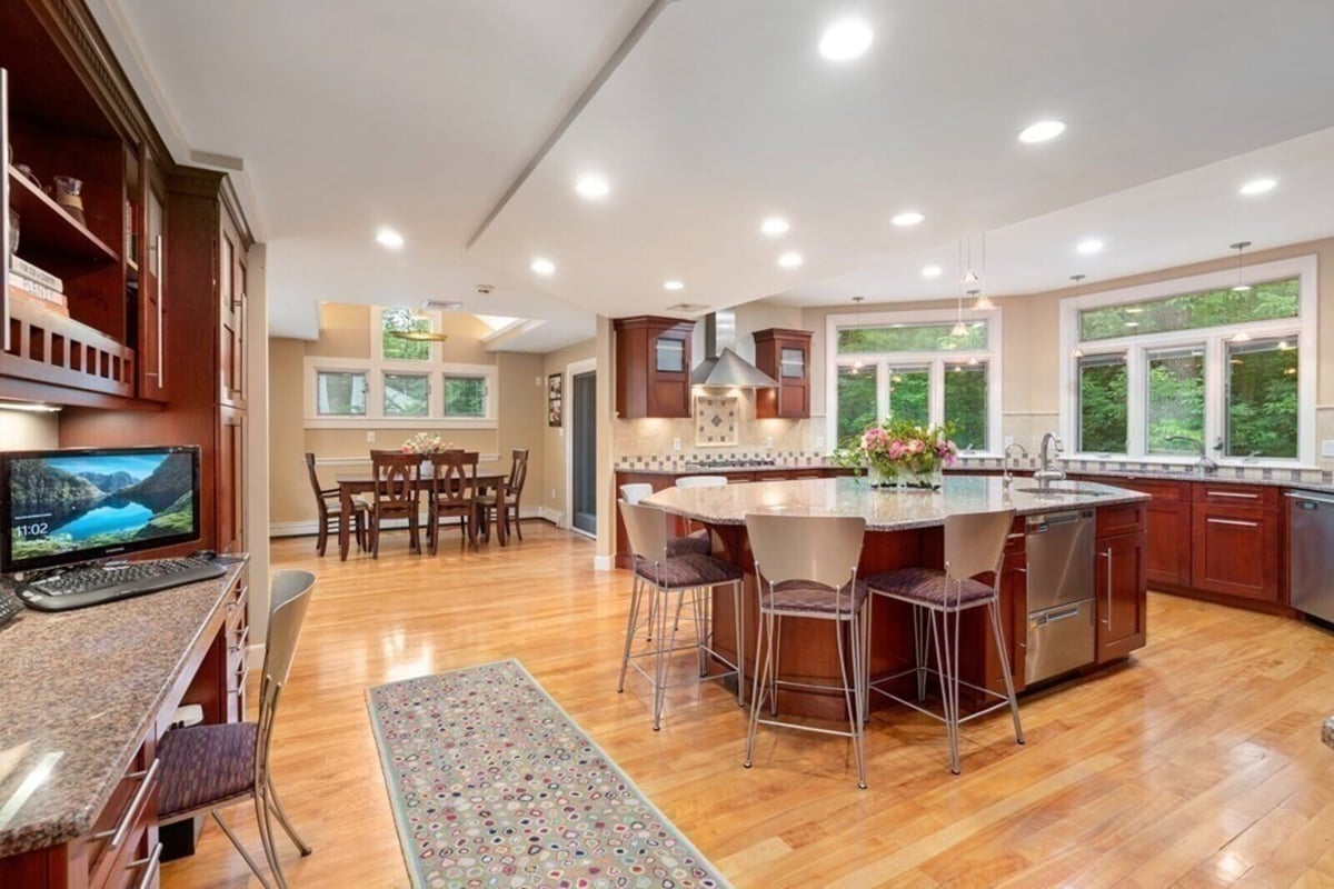 Bright kitchen renovation with granite island and wooden cabinets in Acton, MA by Thomas Buckborough & Associates