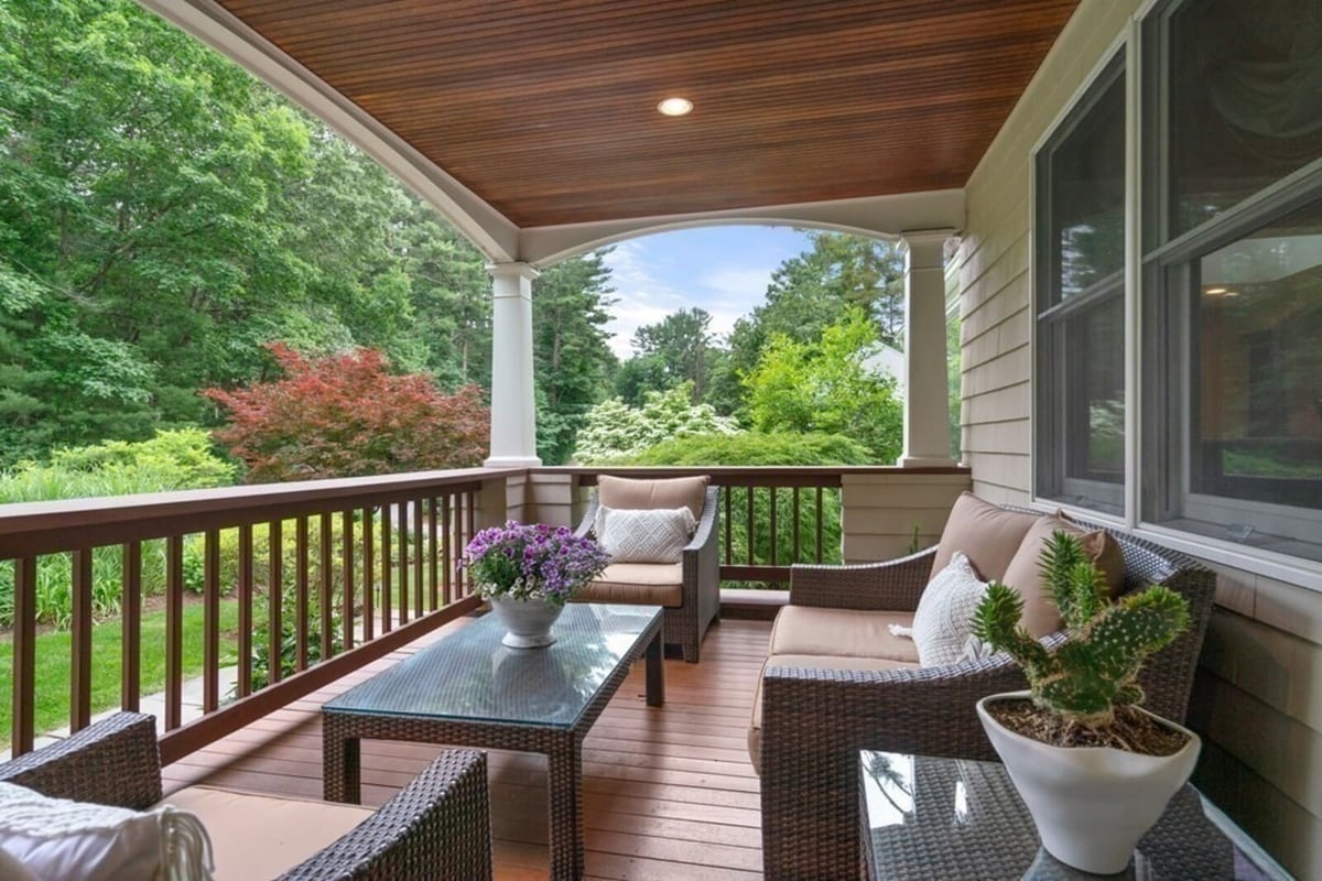 Covered porch overlooking lush landscape in Acton, MA, remodeled by Thomas Buckborough & Associates