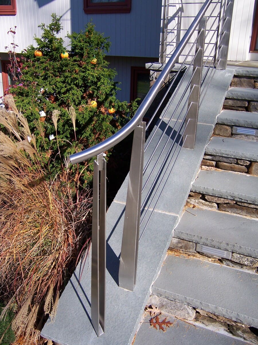 Stainless steel modern stair railing detail in an exterior home remodel by Thomas Buckborough & Associates in Acton, MA