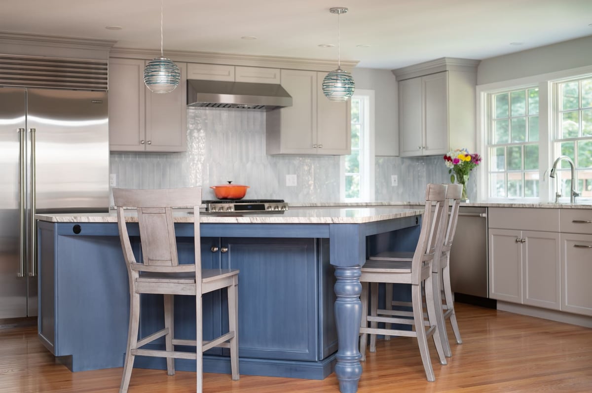 Elegant kitchen remodel by Thomas Buckborough & Associates with a mix of blue and gray cabinetry, wood flooring, and ample natural light