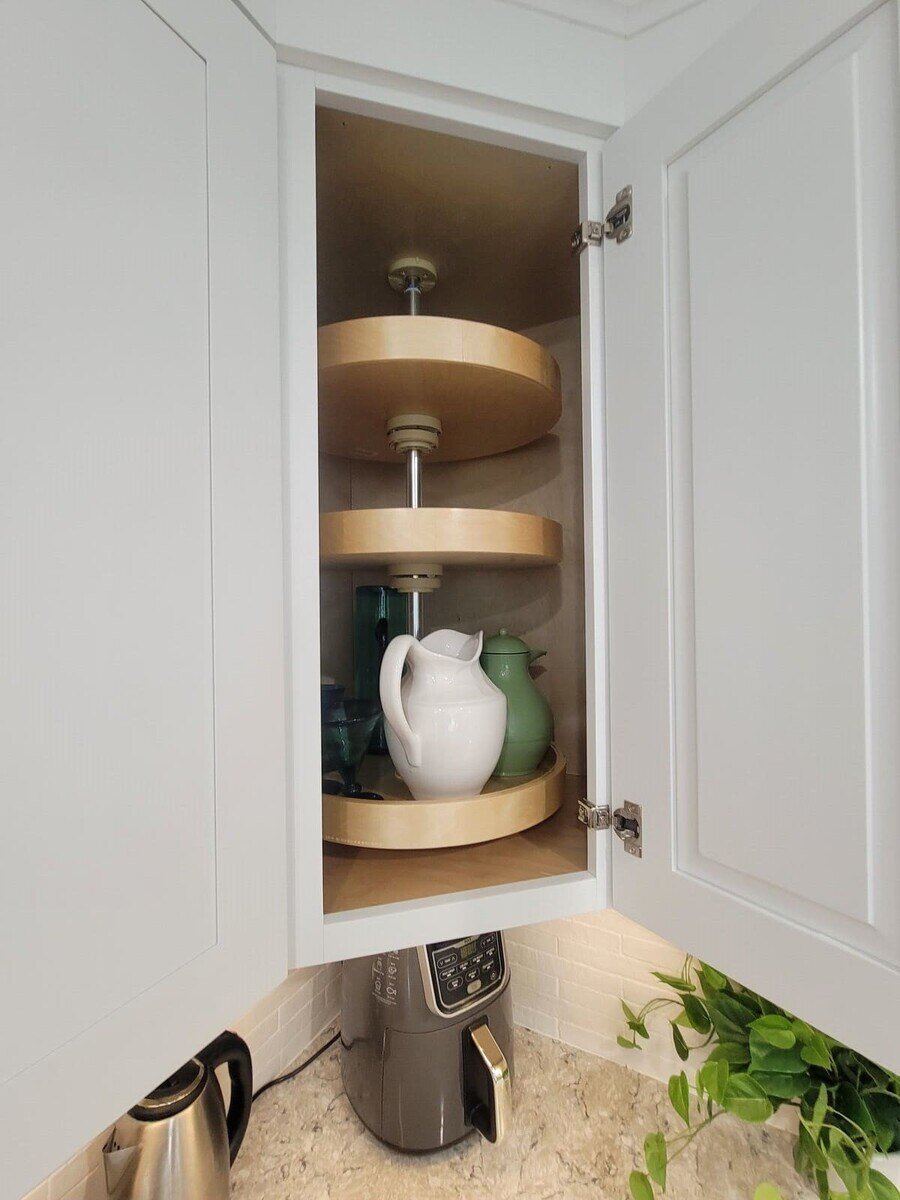 A functional corner cabinet with a built-in Lazy Susan for easy access to dishware in an Acton, MA remodel