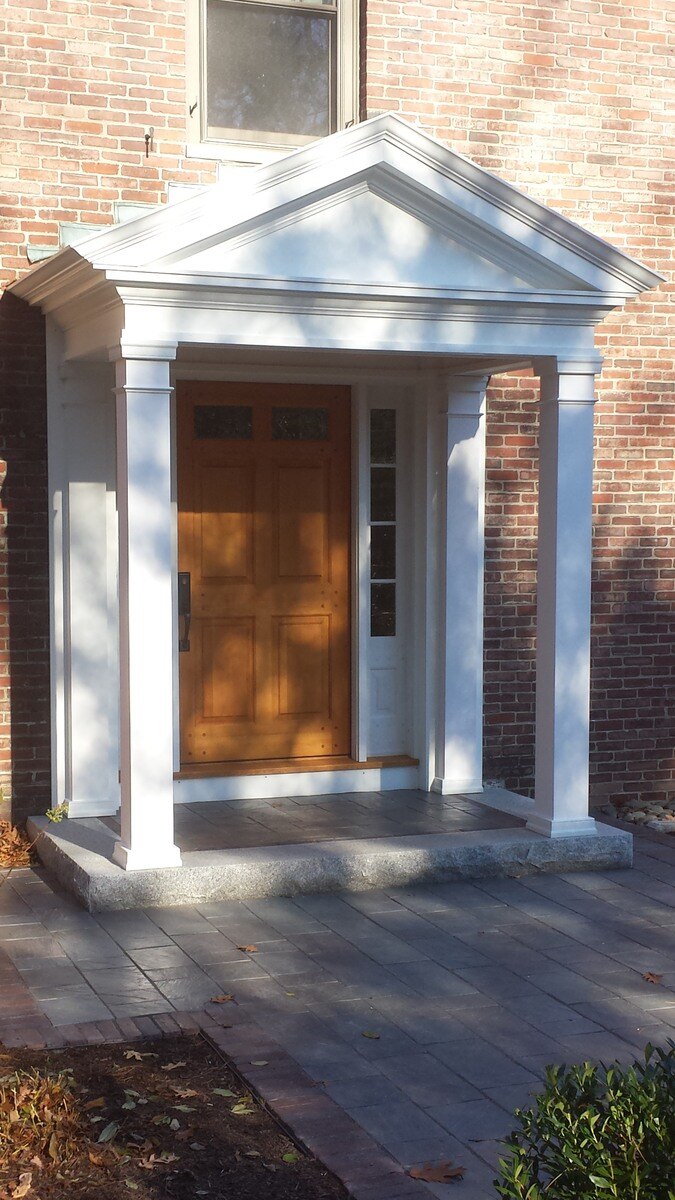 Exterior porch remodel with white portico and wood door by Thomas Buchborough in Greater Boston