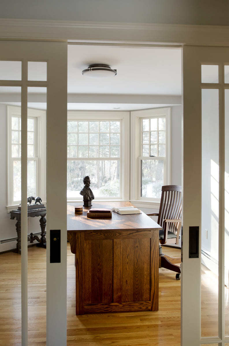 Inviting home office featuring custom wood desk and large windows, project by Thomas Buckborough & Associates, Acton, MA