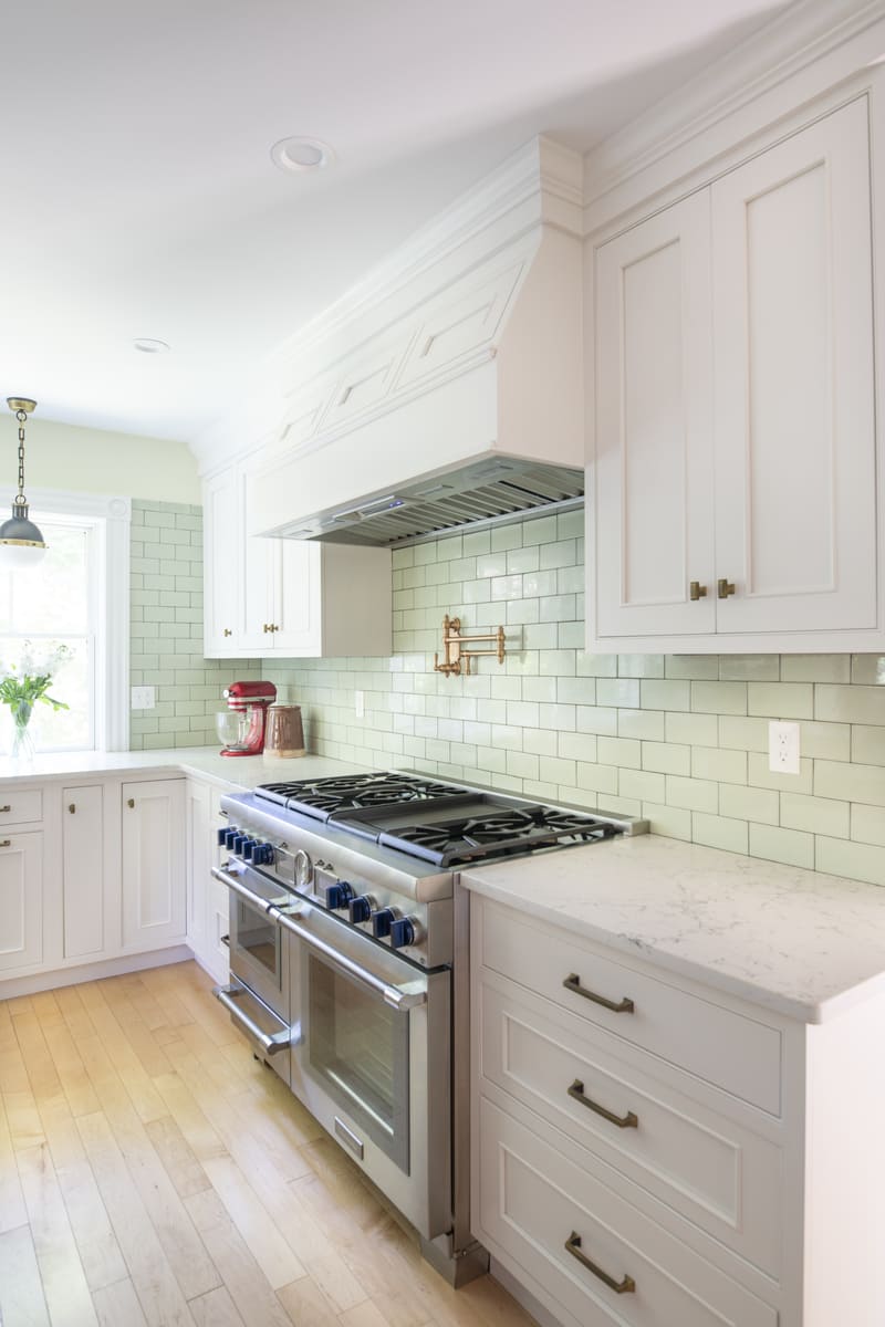 Open kitchen shelving displaying neatly arranged dishes, glassware, and vintage decor in an Acton, MA home remodel